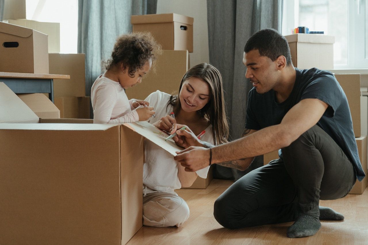 Family of renters in the process of packing boxes for a move.